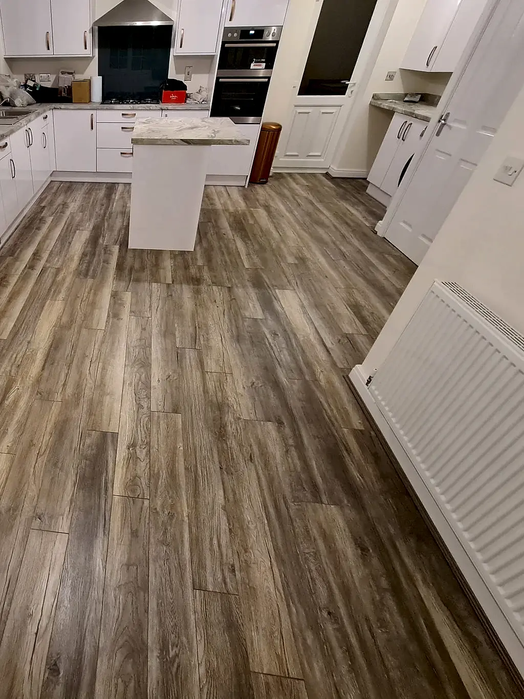 Wood effect laminate flooring fitted through a kitchen