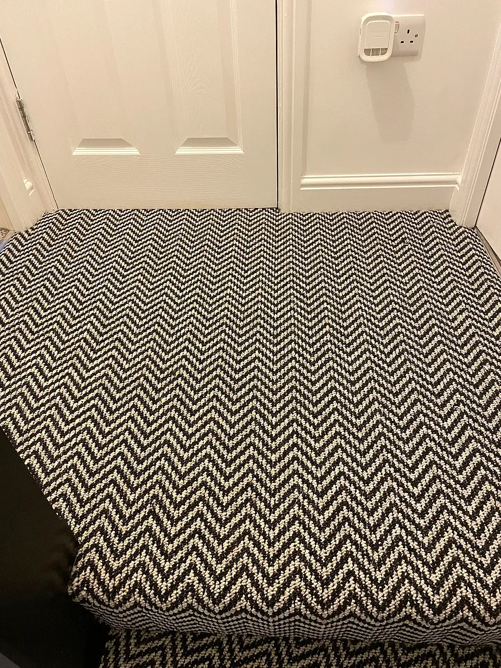 Black and white chevron carpet fitted across a landing